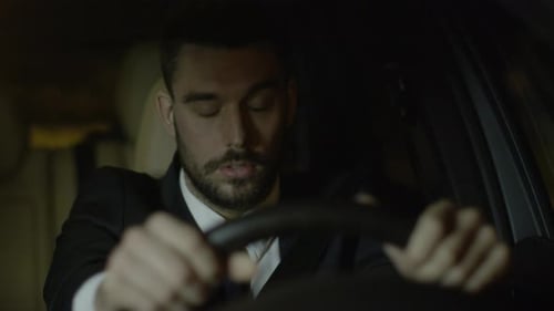 Tired Man Driving at Night in Car