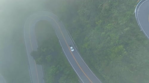 Estrada de montanha curva através de uma floresta tropical exuberante.