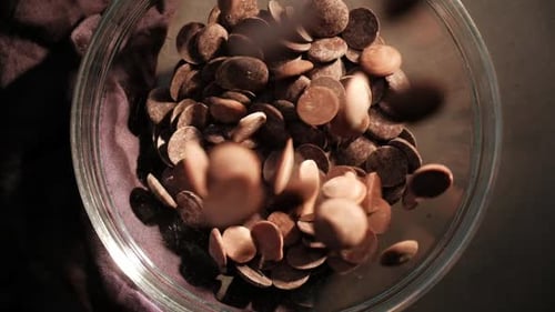 Slowmotion drops falling in a bowl, dark background top view