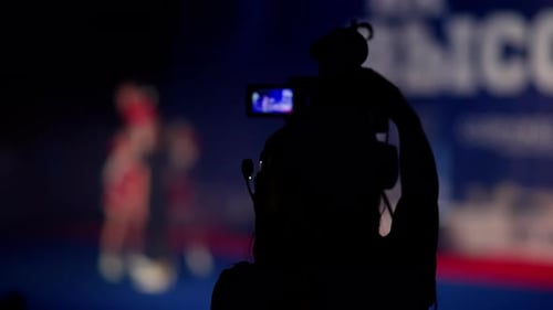 Silhouette of a Cameraman Recording an Event