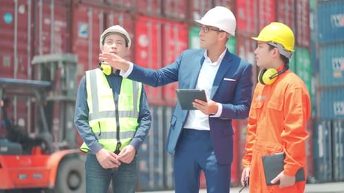 Weitläufige Gruppe von Frachtcontainerarbeitern mit multiethnischem Hintergrund, darunter Ingenieur oder Vorarbeiter