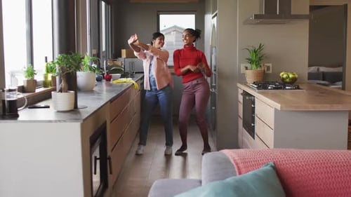 Two Women Dancing and Celebrating in Kitchen