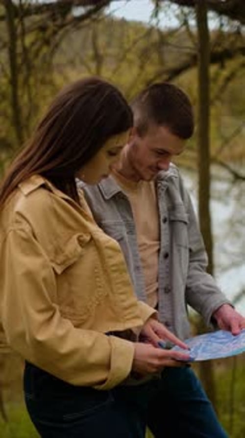 Young Couple Looks at Map While Hiking