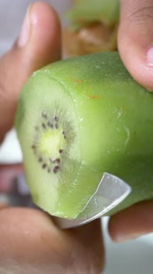 Cutting a Fresh Kiwi Fruit in the Kitchen