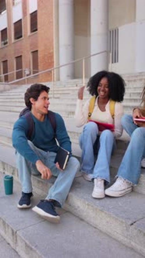 Diverse University Students Socializing and Studying on Campus Steps