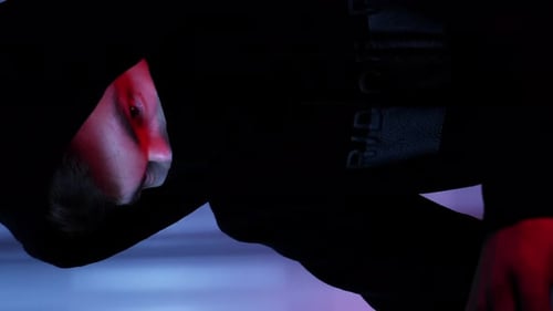 Le visage d'un hacker regarde l'écran de l'ordinateur.