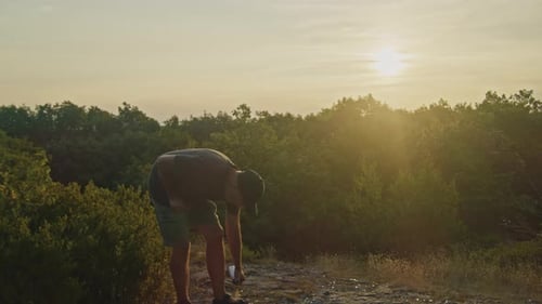 Man Shields Against Mosquitoes with Repellent Spray By the Lake