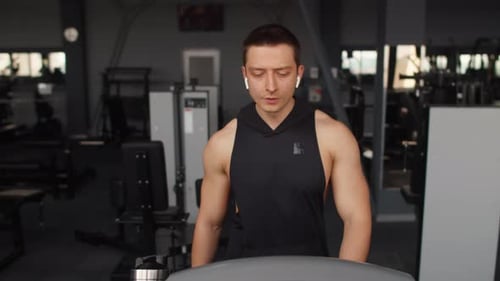 Young Muscle Caucasian Sportsman Starting to Run on the the Treadmill in Indoor Fitness Club Male