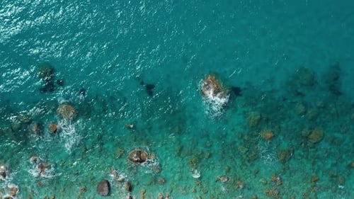 Aerial View of Clear Turquoise Sea and Rocky Shore