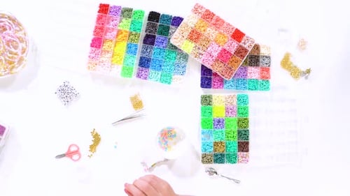 Child Crafting a Colorful Beaded Bracelet Overhead