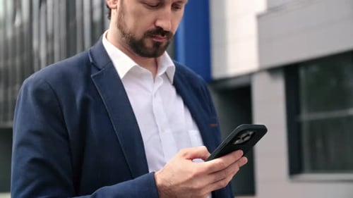 Fashion Bearded Business Man in Suit Smiling Use Smartphone Banking App at Downtown Office Street