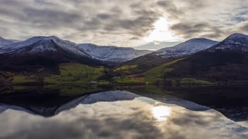 Perfect reflection of mountains and sun in a crystal clear lake in Norway