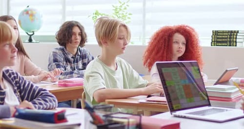 Students Listening Question of Their Teacher That Sitting at Desk with Modern Laptop School Children
