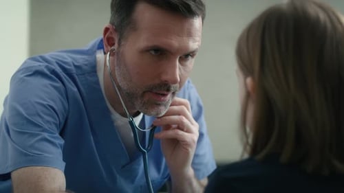 Caring Doctor Talking to Young Patient at Clinic