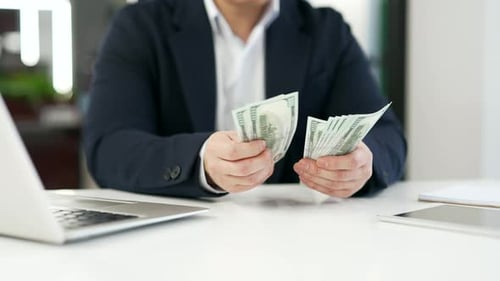 Close up. Male hands count one hundred dollar US bills. Asian businessman in formal suit counting