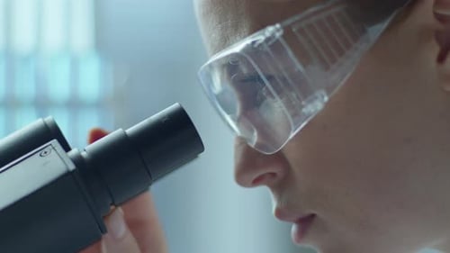 Female Scientist Working with Microscope in Medical Laboratory