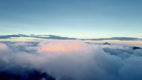 Aerial Drone View Above Clouds at Sunset with Mountain Peak