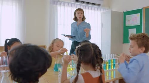 Adorable student learn with teacher in classroom at elementary school.