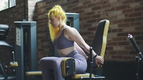 Gorgeous Female Professional Bodybuilder Doing Workout Exercises in Gym