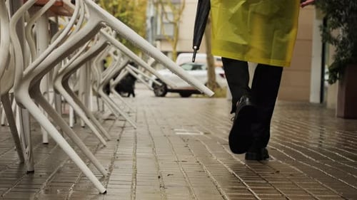Business Man Tourist Person with Umbrella and Raincoat on Rainy European City Street Lights