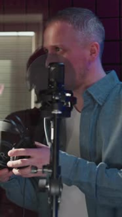 Studio Collaboration Handing Over Headphones in Soundproof Room