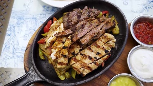 Grilled Chicken and Steak Sizzling on Platter