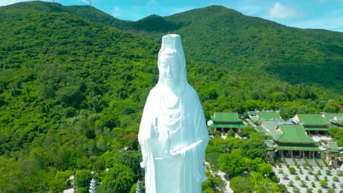 Aerial View Showcasing the Majestic Lady Buddha Statue Surrounded By Lush Greenery and Traditional