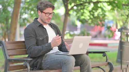 Man on Laptop Having Video Call Outdoors