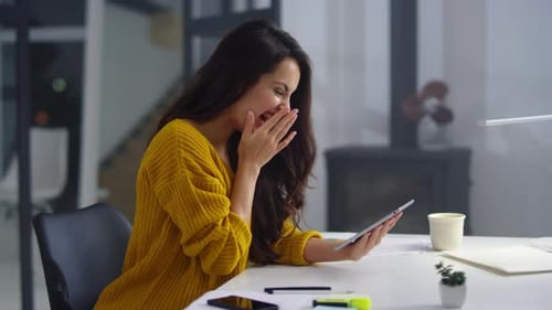Happy young woman uses tablet in modern office