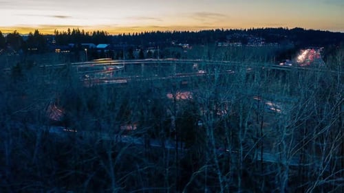 Hyperlapse aérienne d'un échangeur autoroutier très fréquenté et intéressant au coucher du soleil avec des montagnes à l'arrière