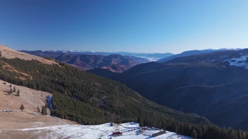 Stunning Aerial View of Snowy Mountain Landscape with Clear Blue Sky