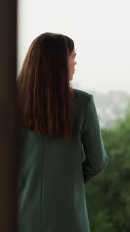 Woman with Long Hair on City Balcony