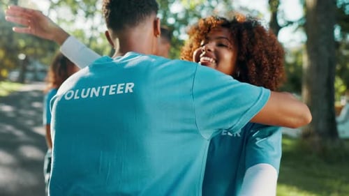 Volunteer, friends and people hug for care, greeting or celebration for teamwork at park