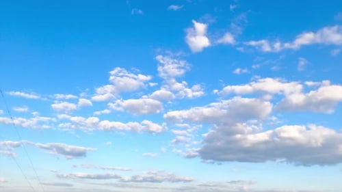 De grands petits nuages séparés flottent dans l'incroyable ciel bleu.
