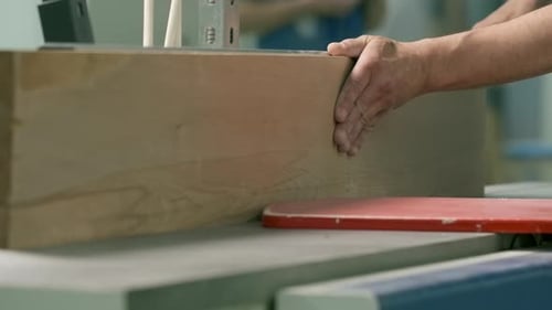Hands Guide Wood Through Cutting Machine