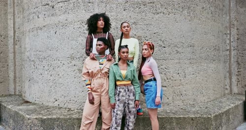 Stylish Women Posing Against Urban Wall