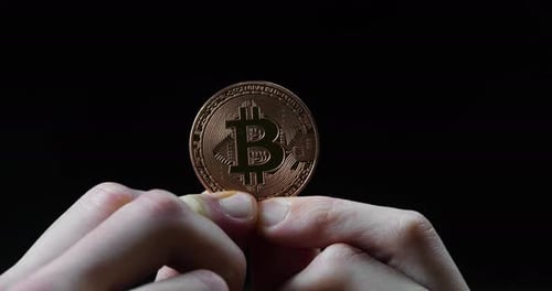 Hands Holding Shiny Copper Bitcoin Coin