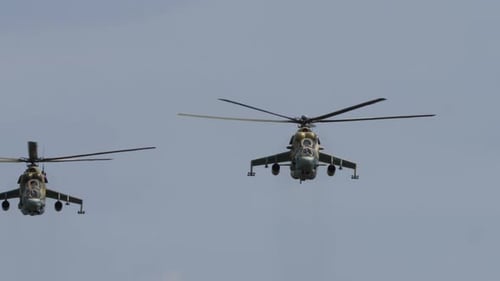 Two Military Helicopters Fly in Formation