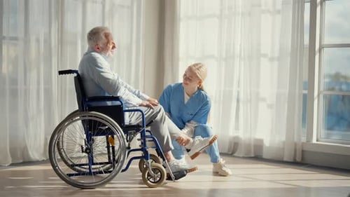 Caregiver Helping Senior Man in Wheelchair