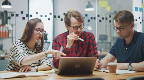 Team Discussing Project with Laptop at Office Table