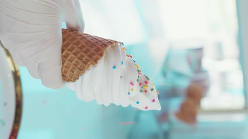 Cooking vanilla ice cream in a bean cup that is sprinkled with multi-colored sugar sprinkles