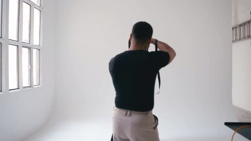 Professional Photographer Taking Pictures of Fashion Model in Studio