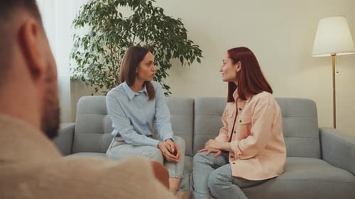 Two Women Discussing a Topic on a Couch