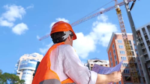 Construction Worker Examining Blueprint at Construction Site