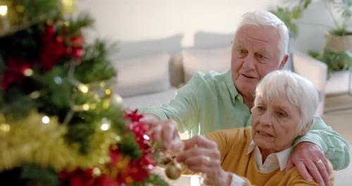 Senior Couple Decorating Christmas Tree with Love
