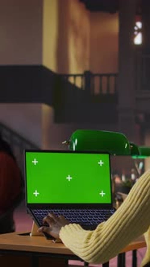 Vertical Video Preteen Scholar Works on a School Assignment with Green Screen in the Library