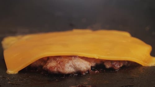 Cooking American Fat Smash Burger with Cheese Slice on Top on Grill Closeup Beef or Pork Cutlet