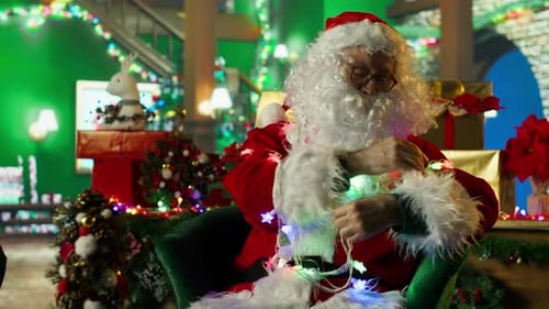 Santa Claus Entangled in Led Lights While Adorning Workshop for Christmas