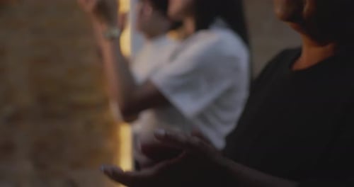 Close-up of diverse group clapping hands during spiritual gathering, elderly woman in foreground