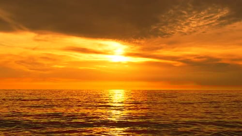 Sunset Ocean Water Golden Hour Over Calm Sea with Vibrant Orange Sky and Sun Reflection on the Waves
